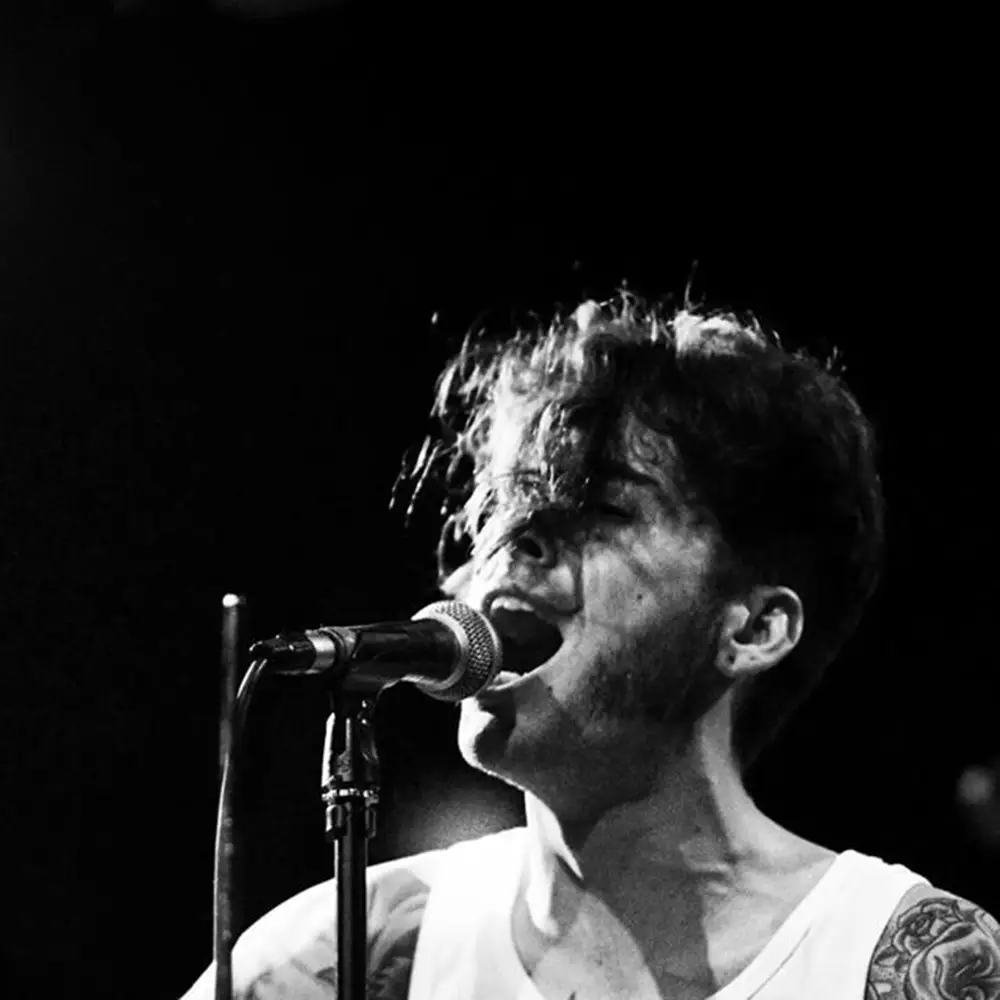 Don Rogelio cantando diante dun micrófono