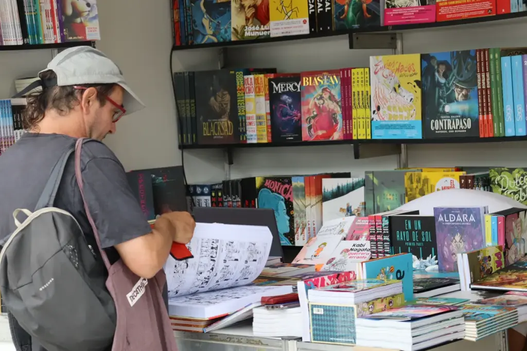 Persoa vendo libros nun posto da rúa BD