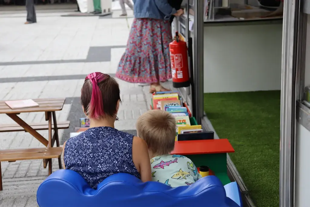 Un neno e una nena lendo un libro na rúa BD do festival de Viñetas desde o Atlántico