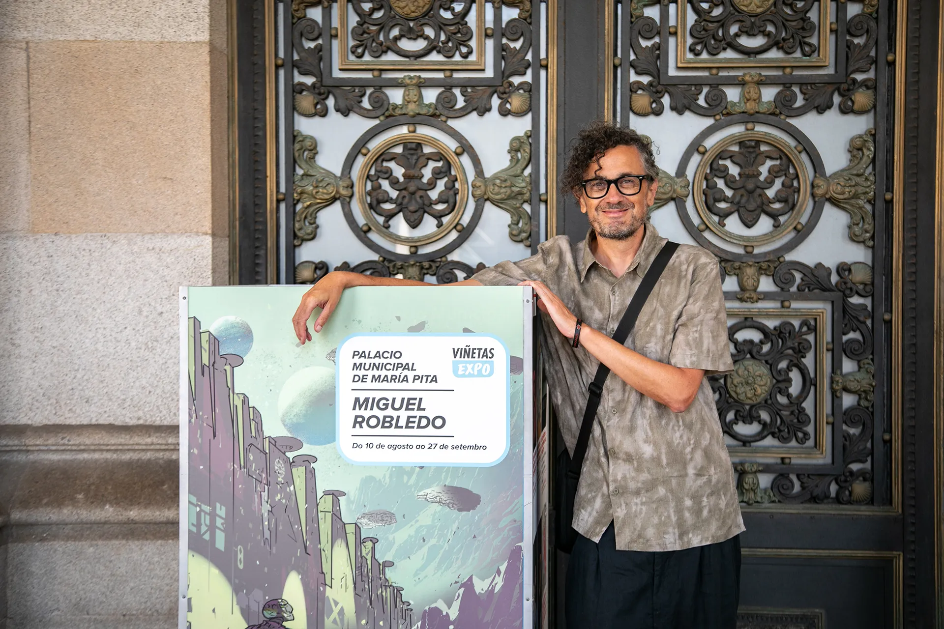 Miguel Robledo na porta do Concello co cartel da s&uacute;a exposici&oacute;n