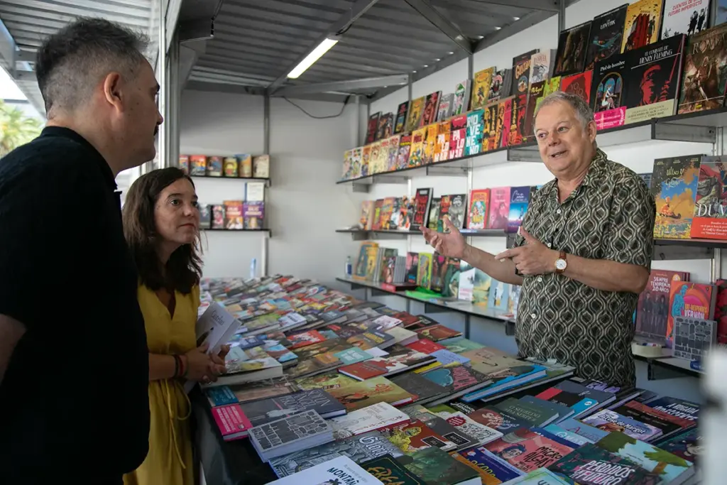A alcaldesa Inés Rey e o director do festival Manel Cráneo falan cos libreiros das casetas de Rúa BD