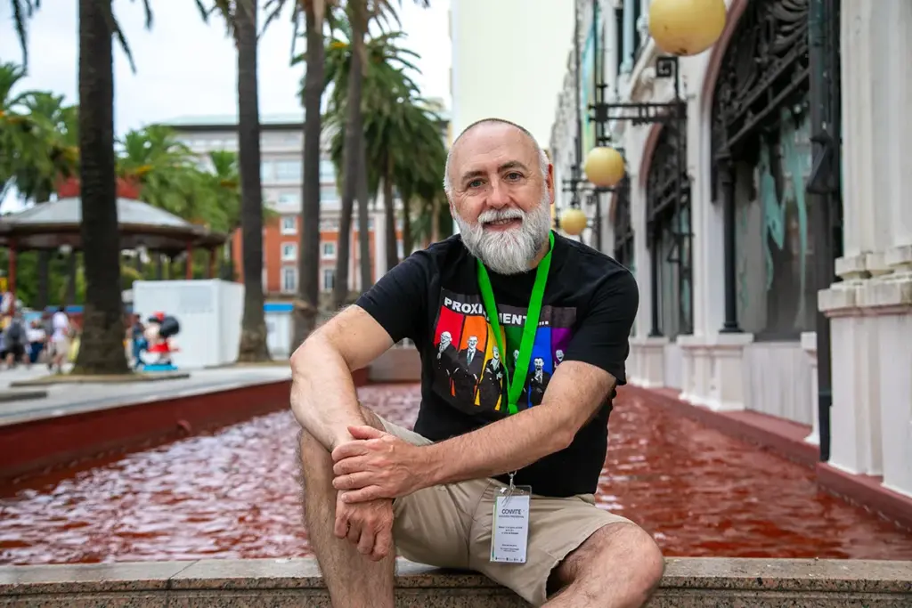O ilustrador Sebas Martín sentado a carón da fonte do Kiosko Alfonso